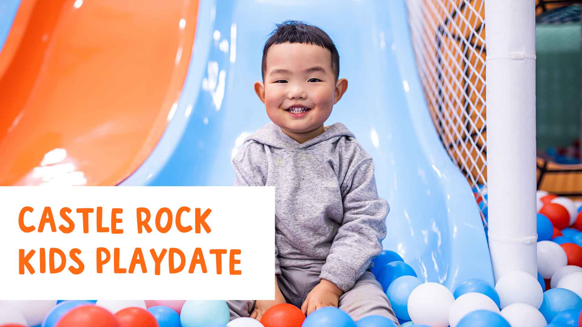 Smiling boy on slide in ball pit. Castle Rock Kids Playdate