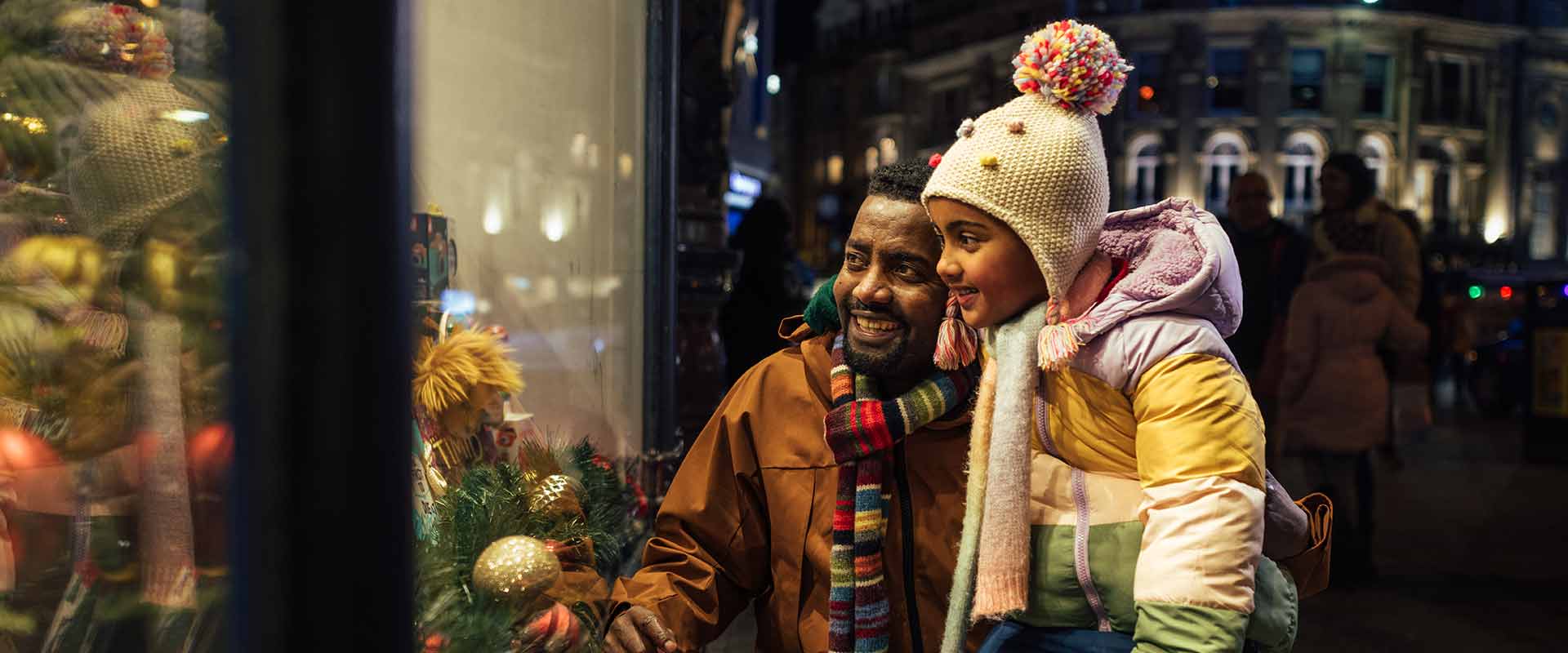 dad and daughter looking in window at christmas