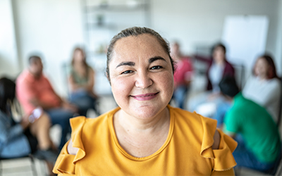 woman smiling with a group of people behind her